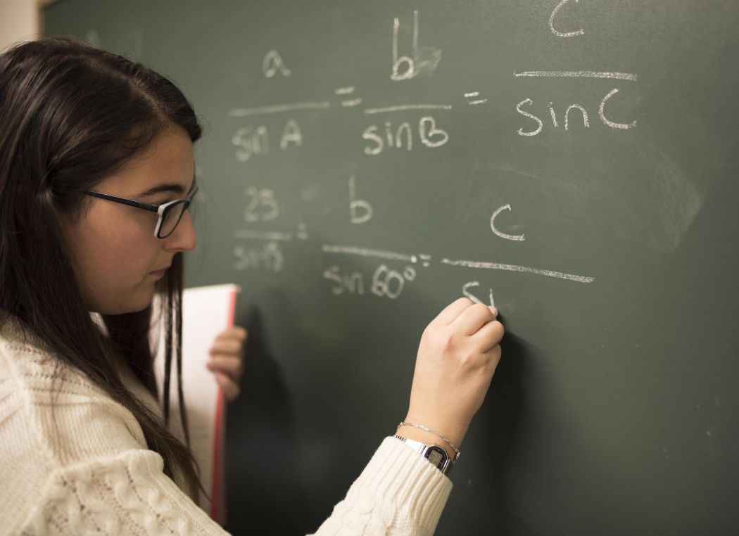 student making maths on chalkboard